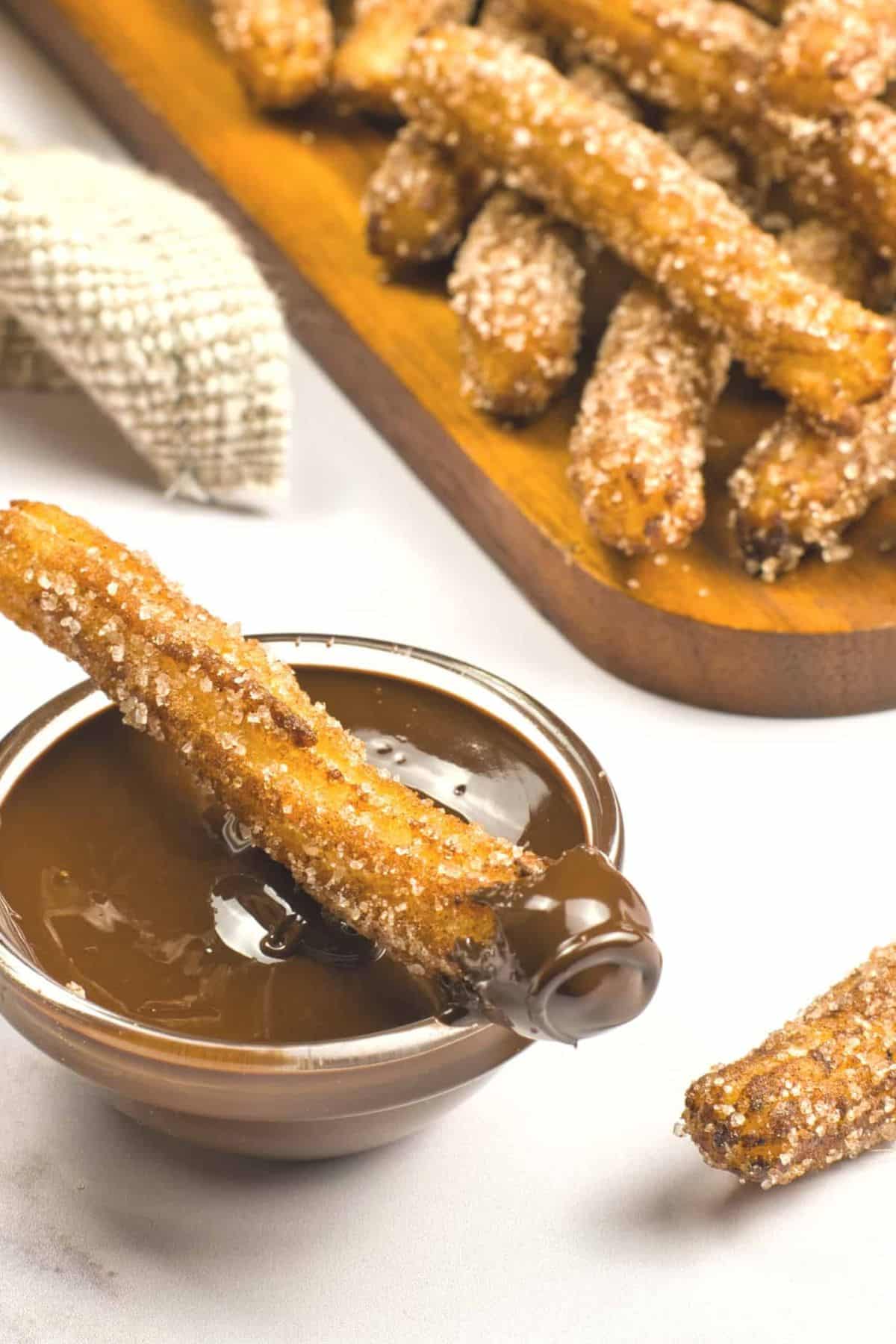 A churro dipped in melted chocolate.