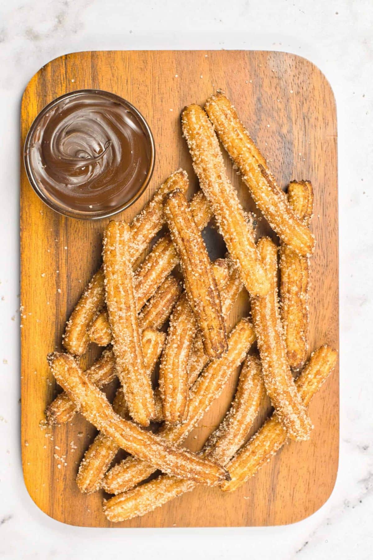 Top down view of gluten-free vegan churros on wooden board.