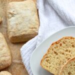 Pieces of ciabatta bread on plate and parchment paper.