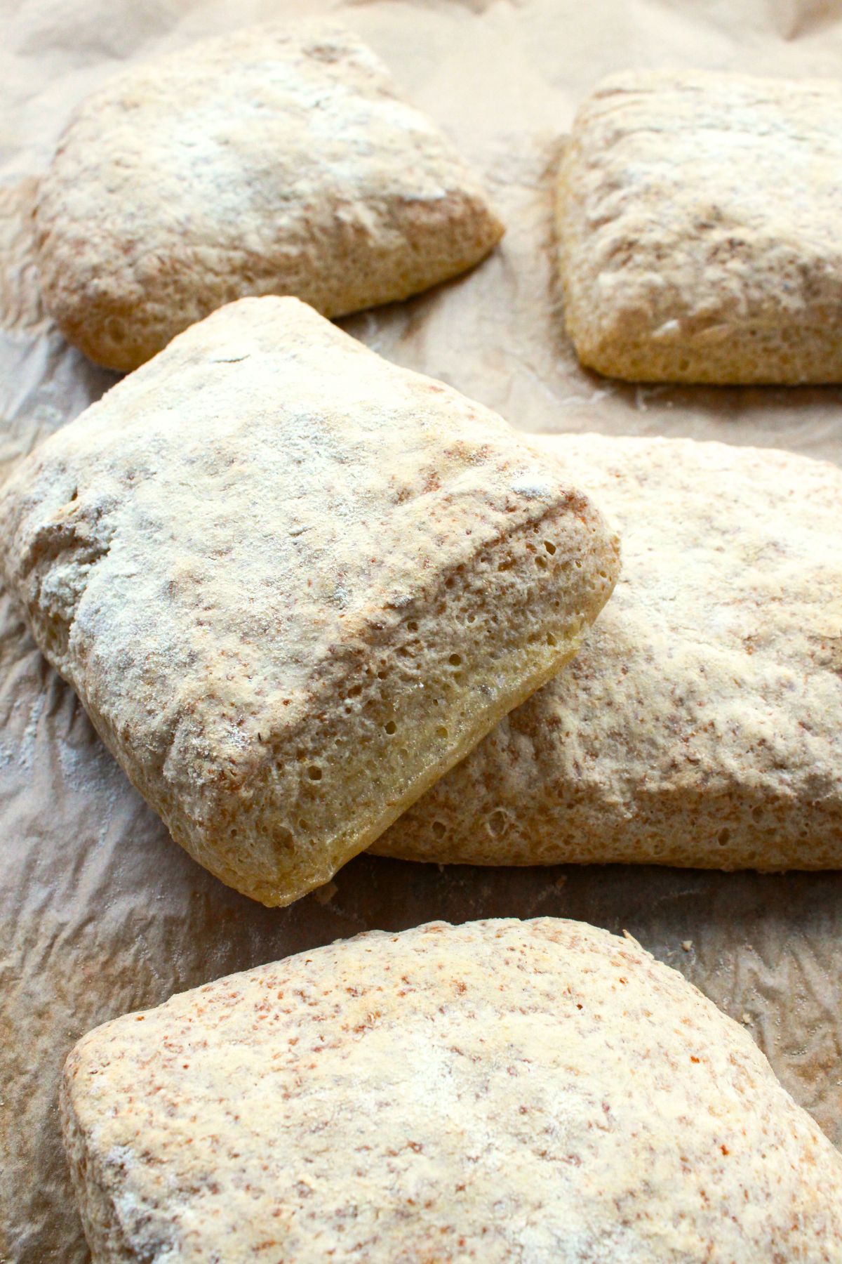 Gluten-free ciabatta rolls on parchment paper.