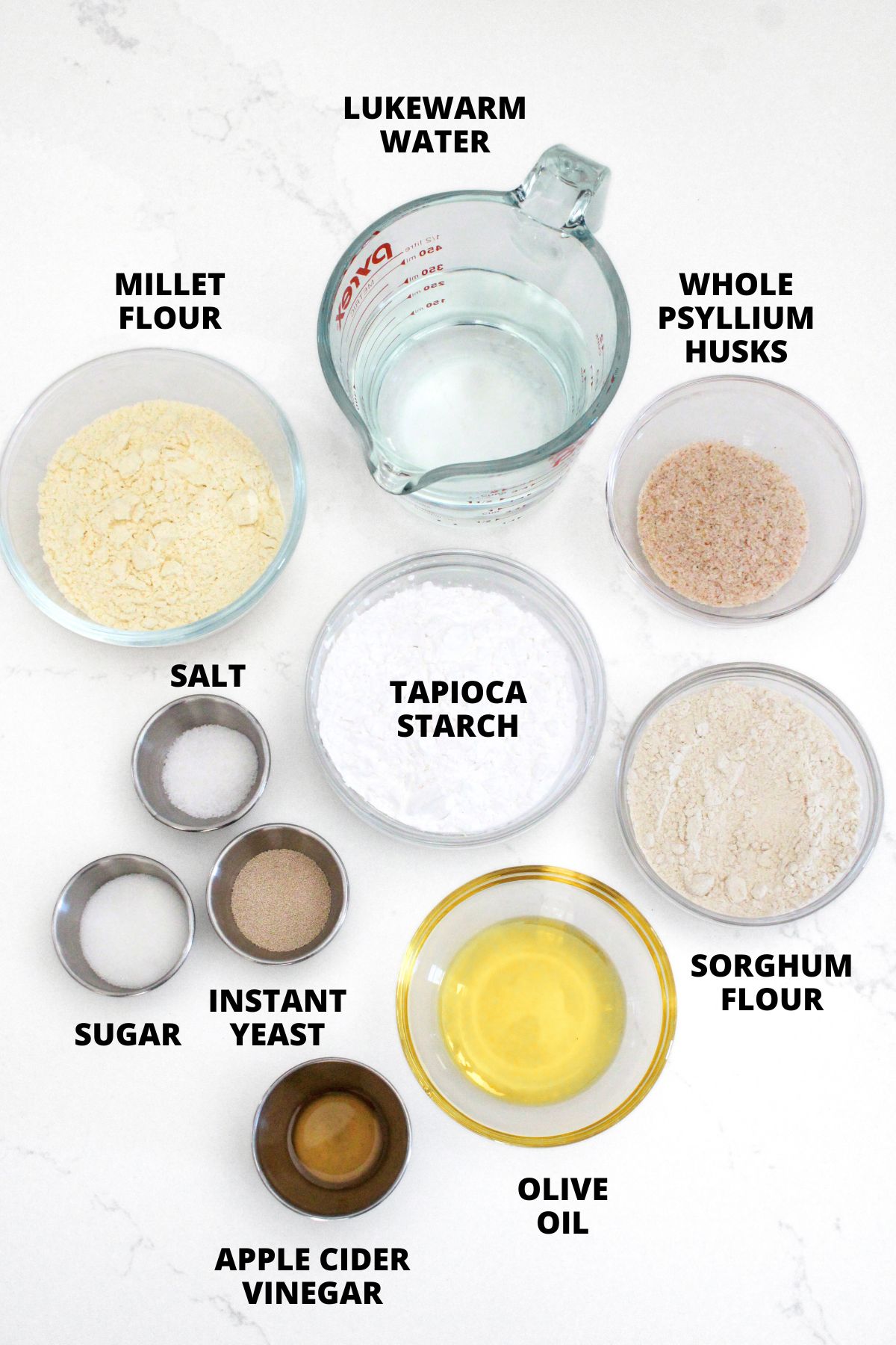 Ingredients for gluten-free ciabatta recipe laid out on white board.