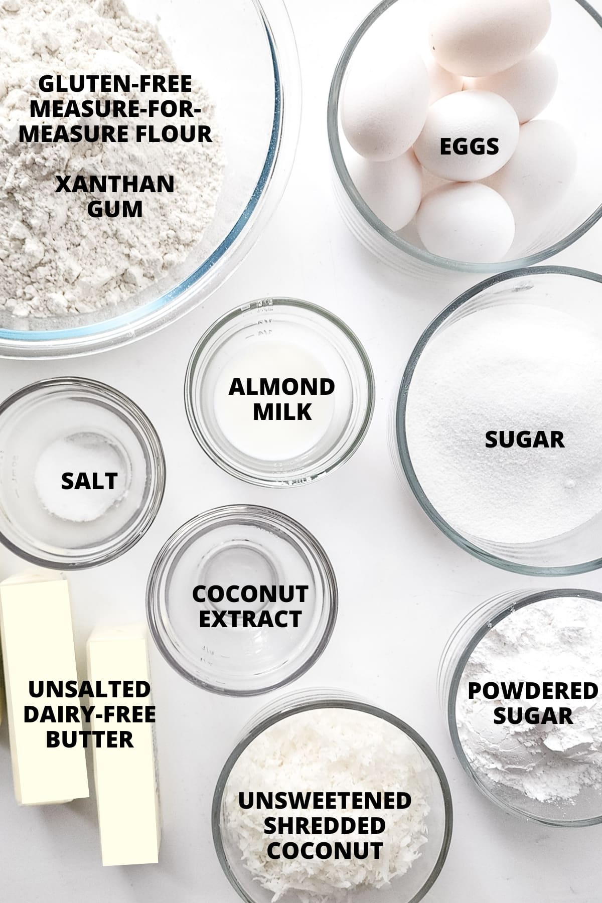 Ingredients for gluten-free coconut cake recipe laid out on white board.