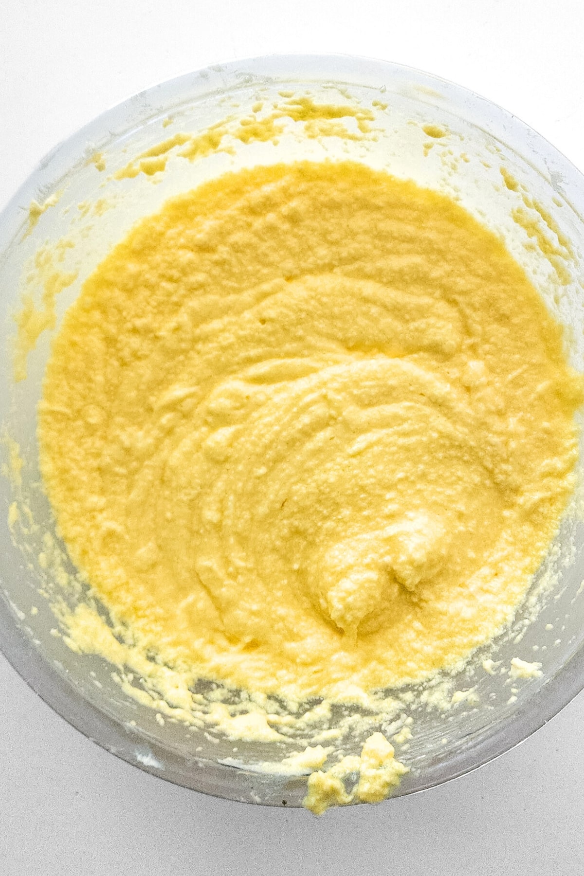 Pale yellow batter in glass bowl.