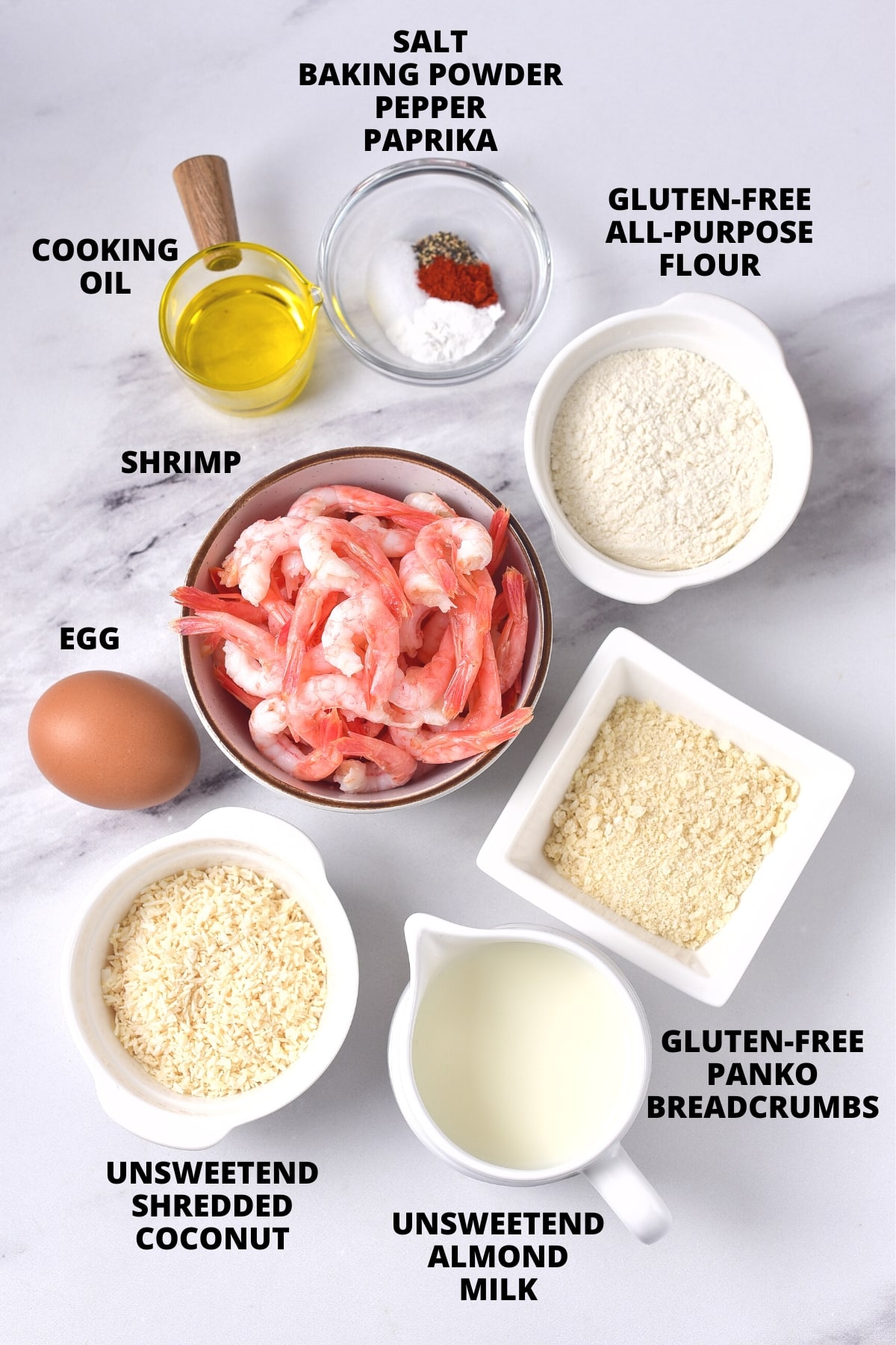 Ingredients for crispy coconut shrimp recipe laid out on marble board.