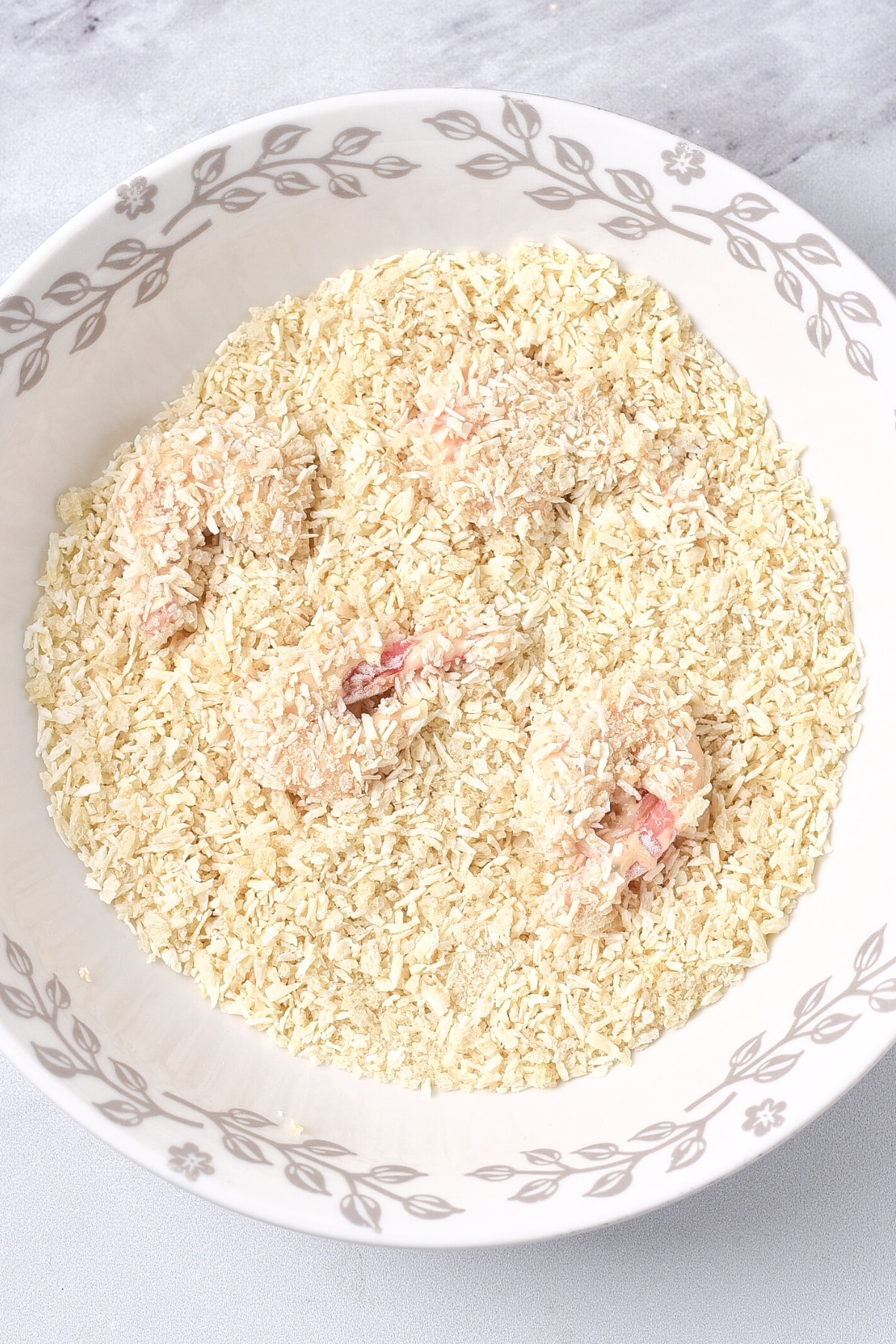 Coating shrimp in gluten-free panko mixture.