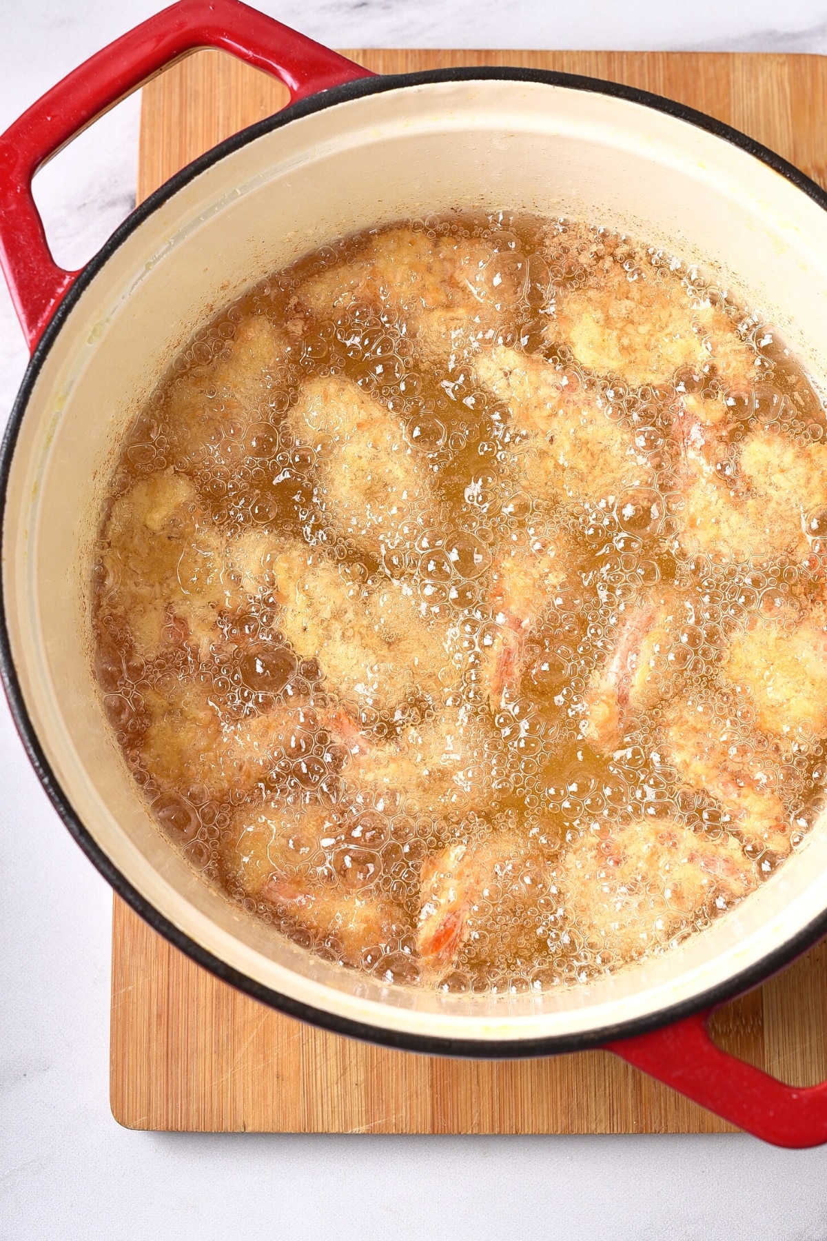 Deep-frying gluten-free coconut shrimp in a pot of oil.