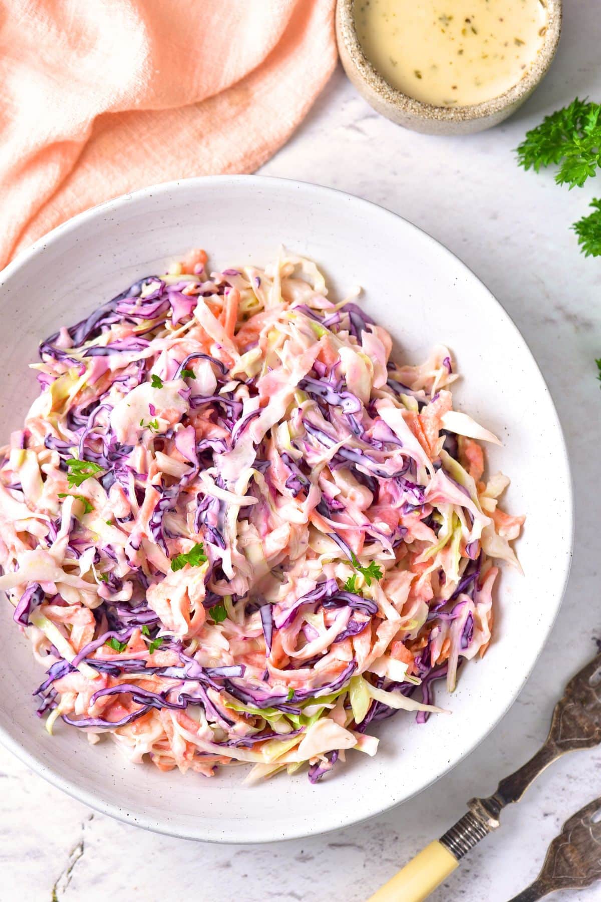 Top down view of a bowl of gluten-free coleslaw on marble board.