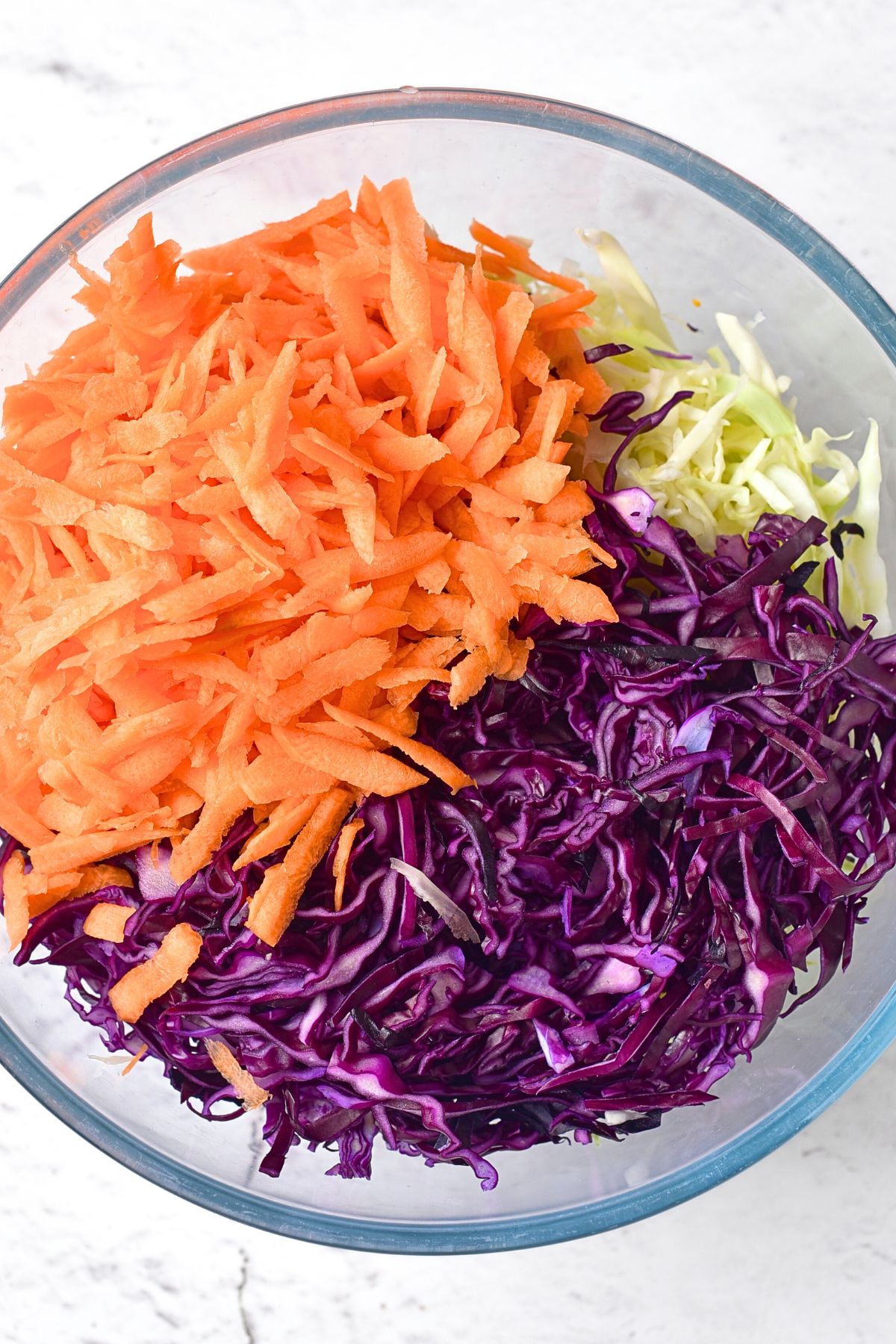 A bowl of shredded cabbage and carrots.