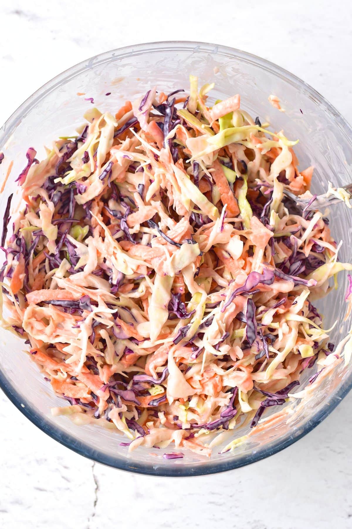 Homemade coleslaw in a glass bowl.