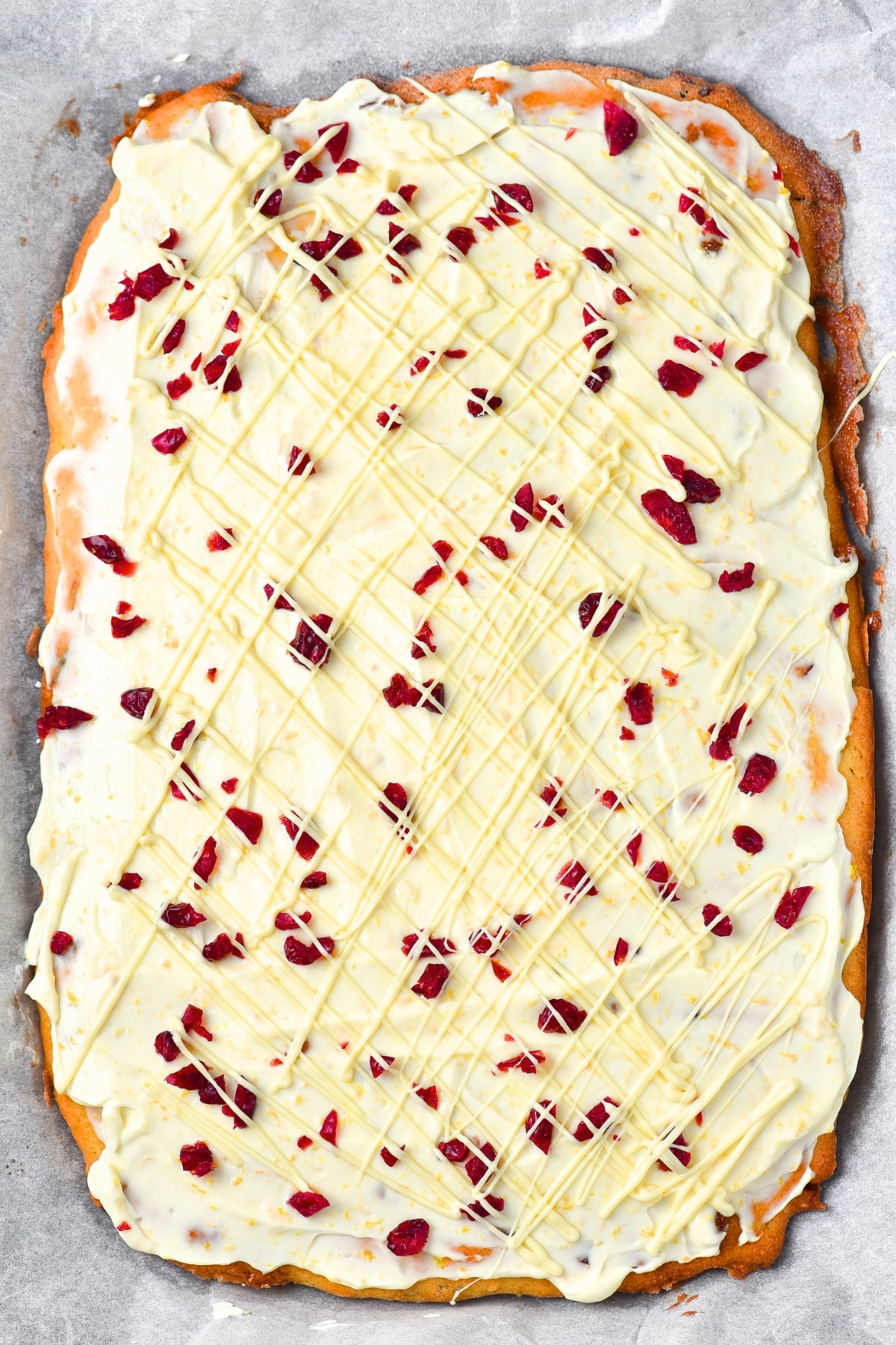 White chocolate drizzled over cranberry cake.