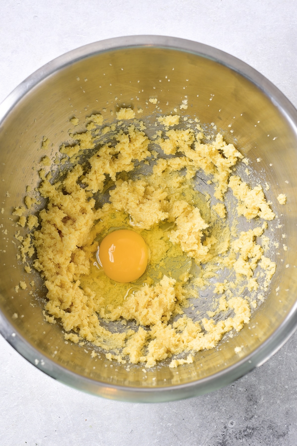 Egg on top of yellow mixture in bowl.