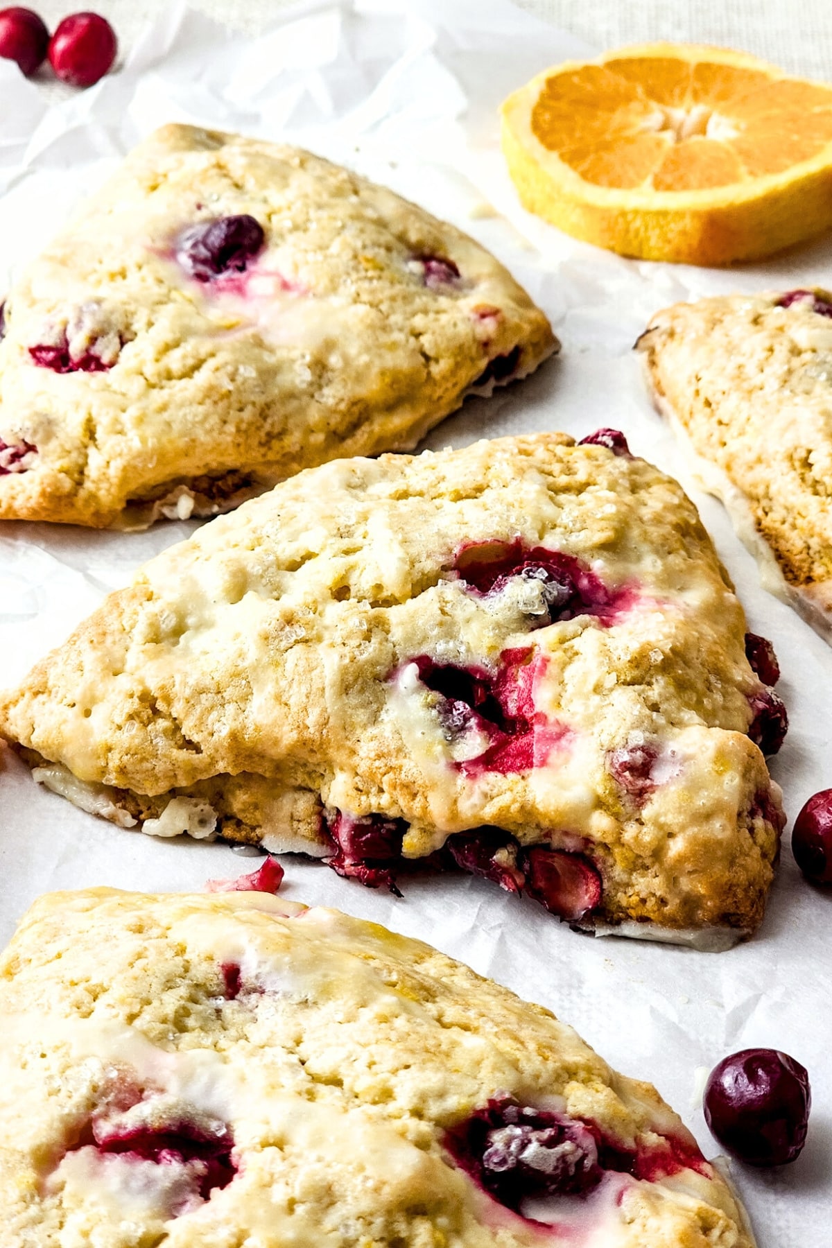 Up close shot of gluten-free cranberry orange scones on parchment paper.