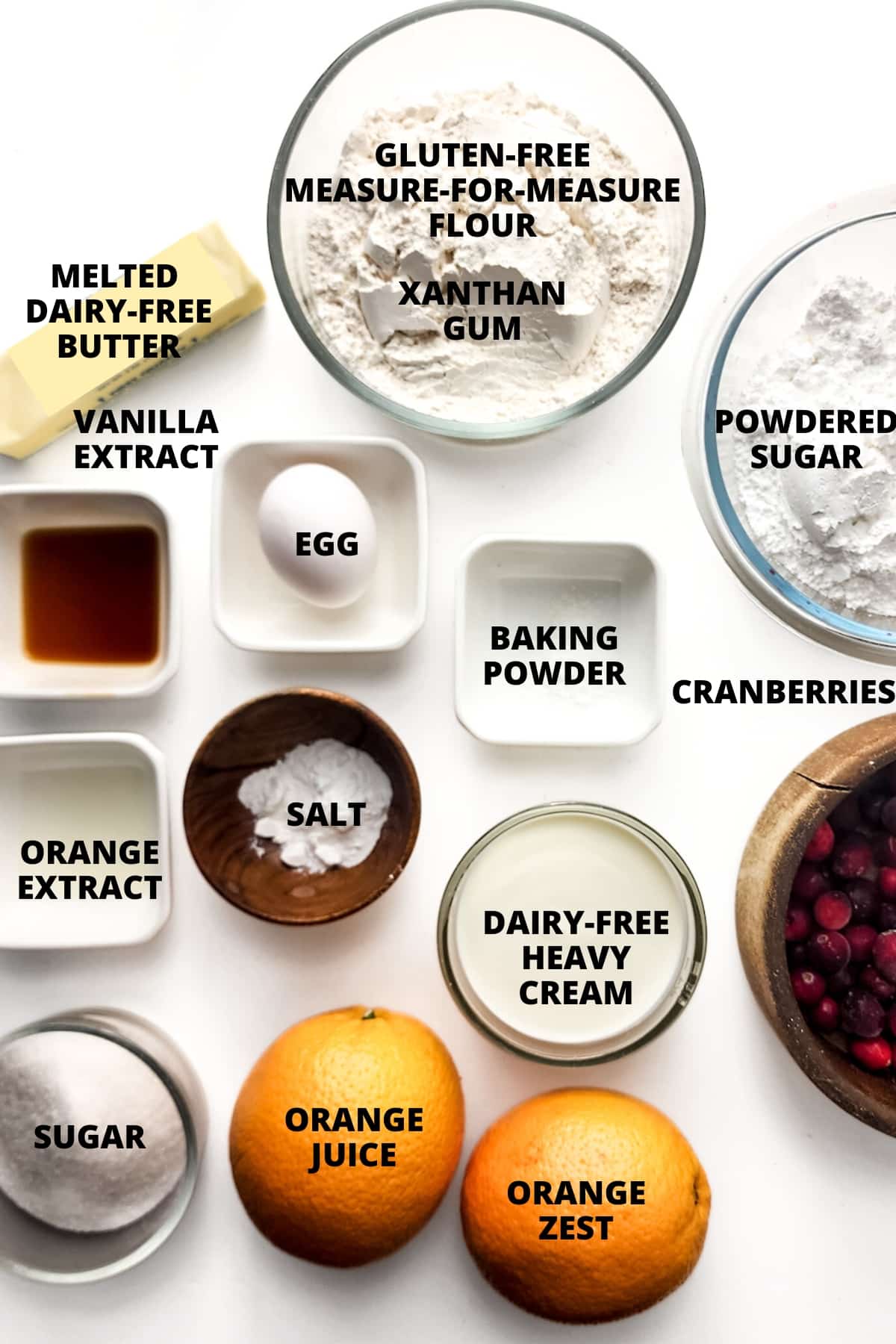 Ingredients for gluten-free cranberry orange scones recipes laid out on white board.