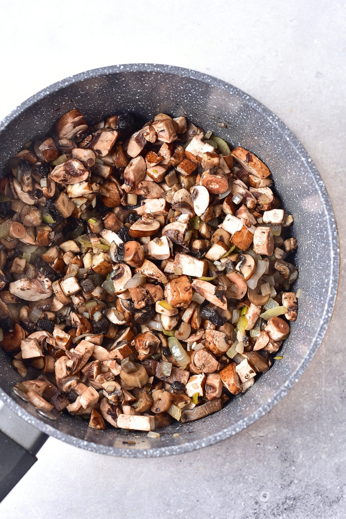 Sautéed mushrooms and onions in saucepan.