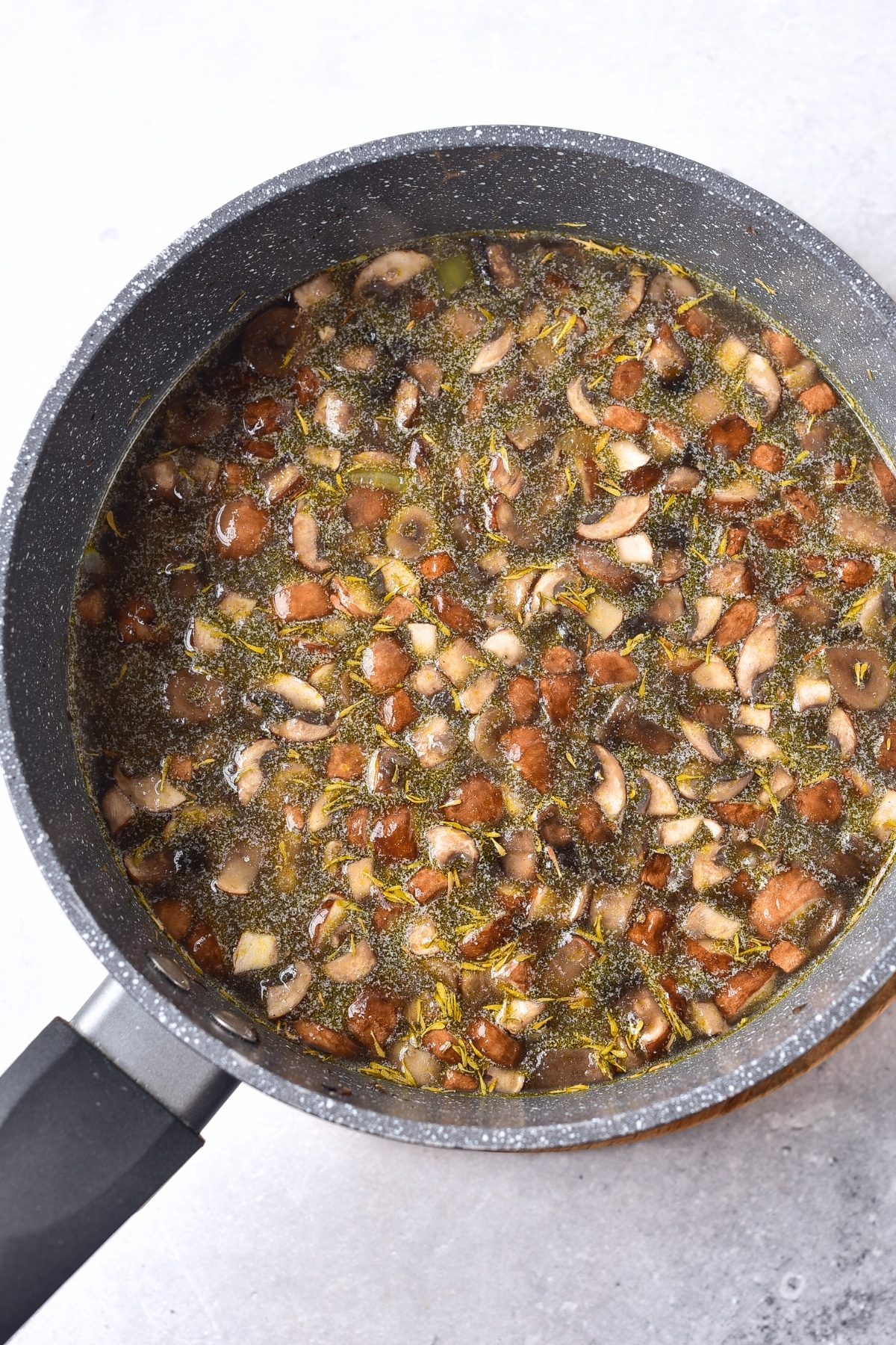 Cooked mushrooms and broth in a pot.