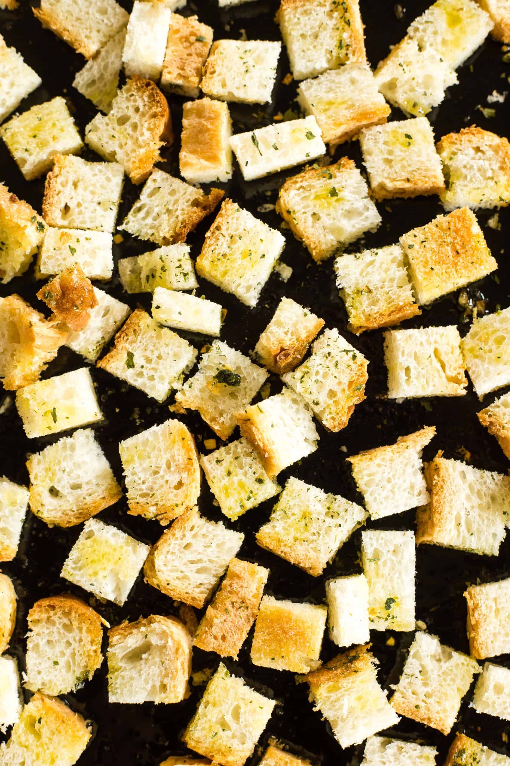 Gluten-free croutons spread out on a baking sheet