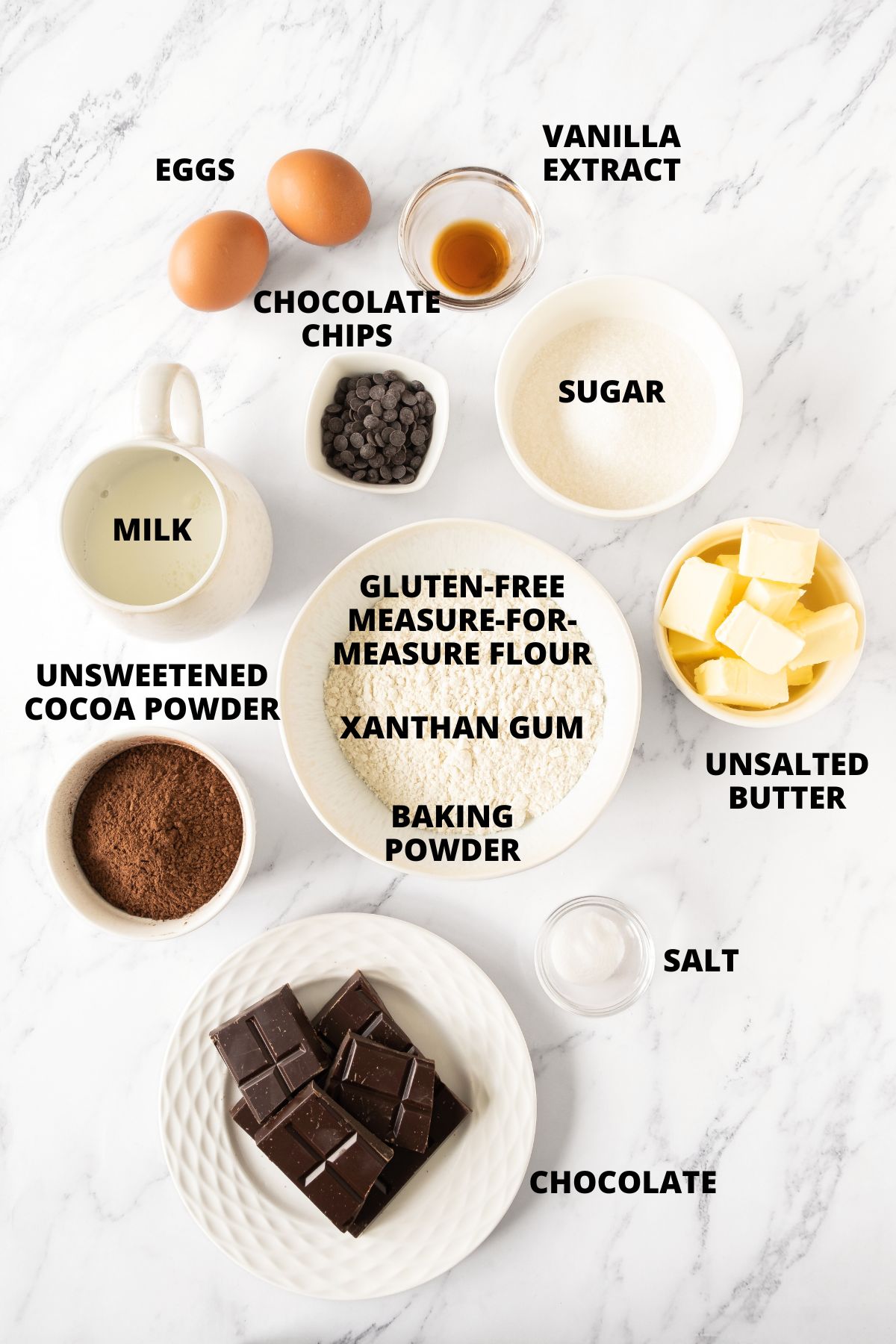 Ingredients for gluten-free chocolate muffins recipe laid out on marble board.