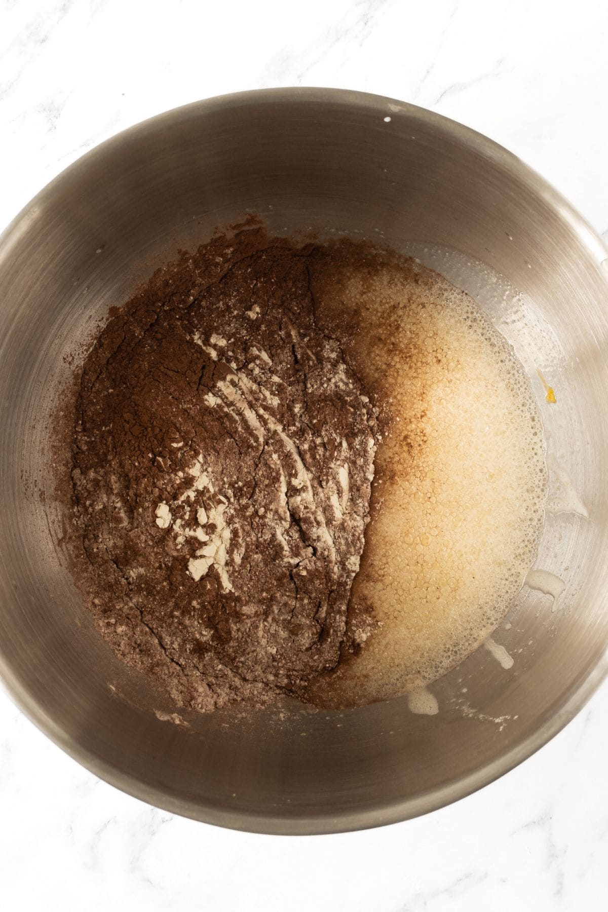 Chocolate flour mixture with pale yellow liquid in bowl