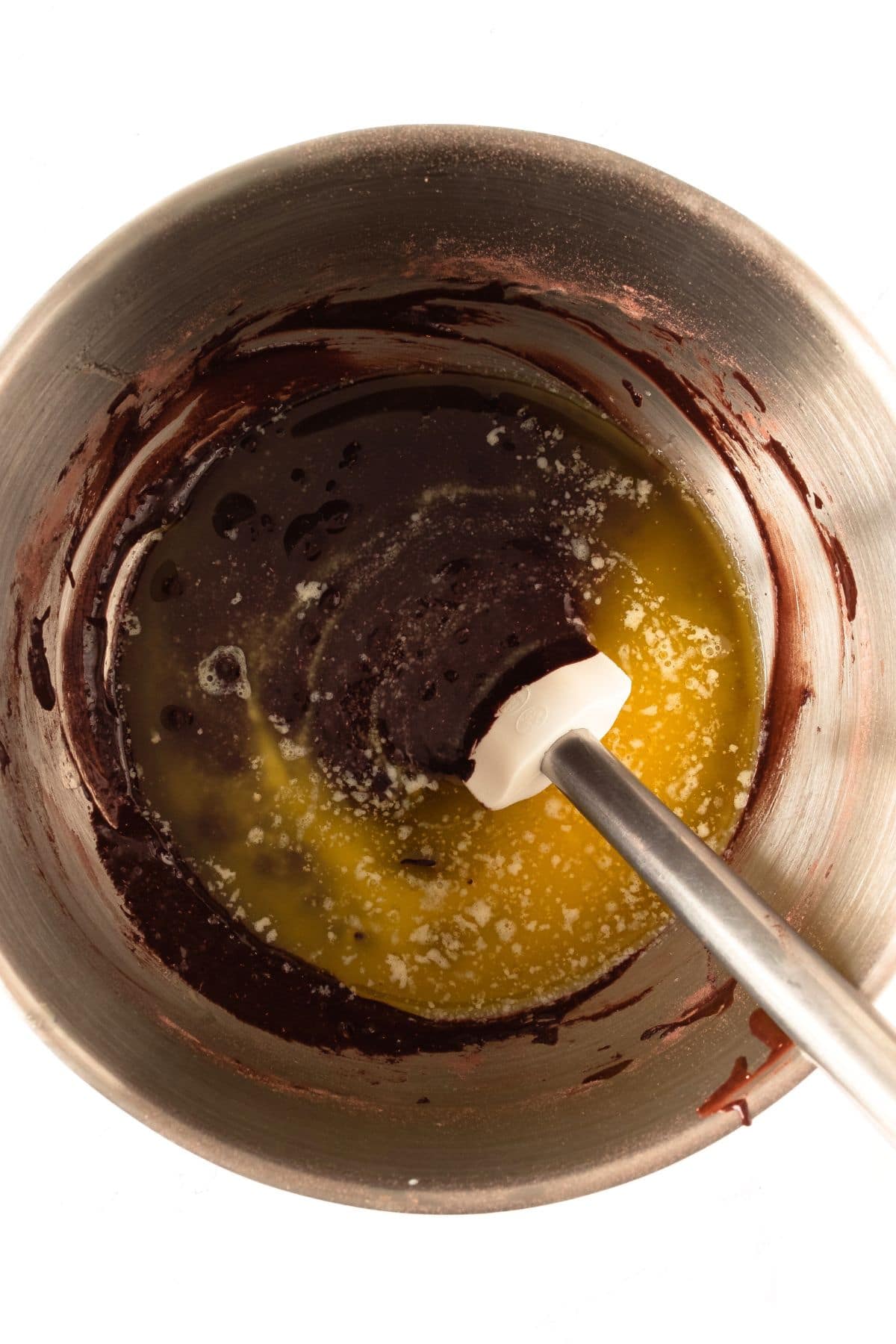 Mixing melted chocolate and butter in bowl