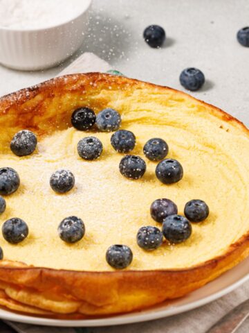 Dutch baby topped with fresh blueberries and powdered sugar.
