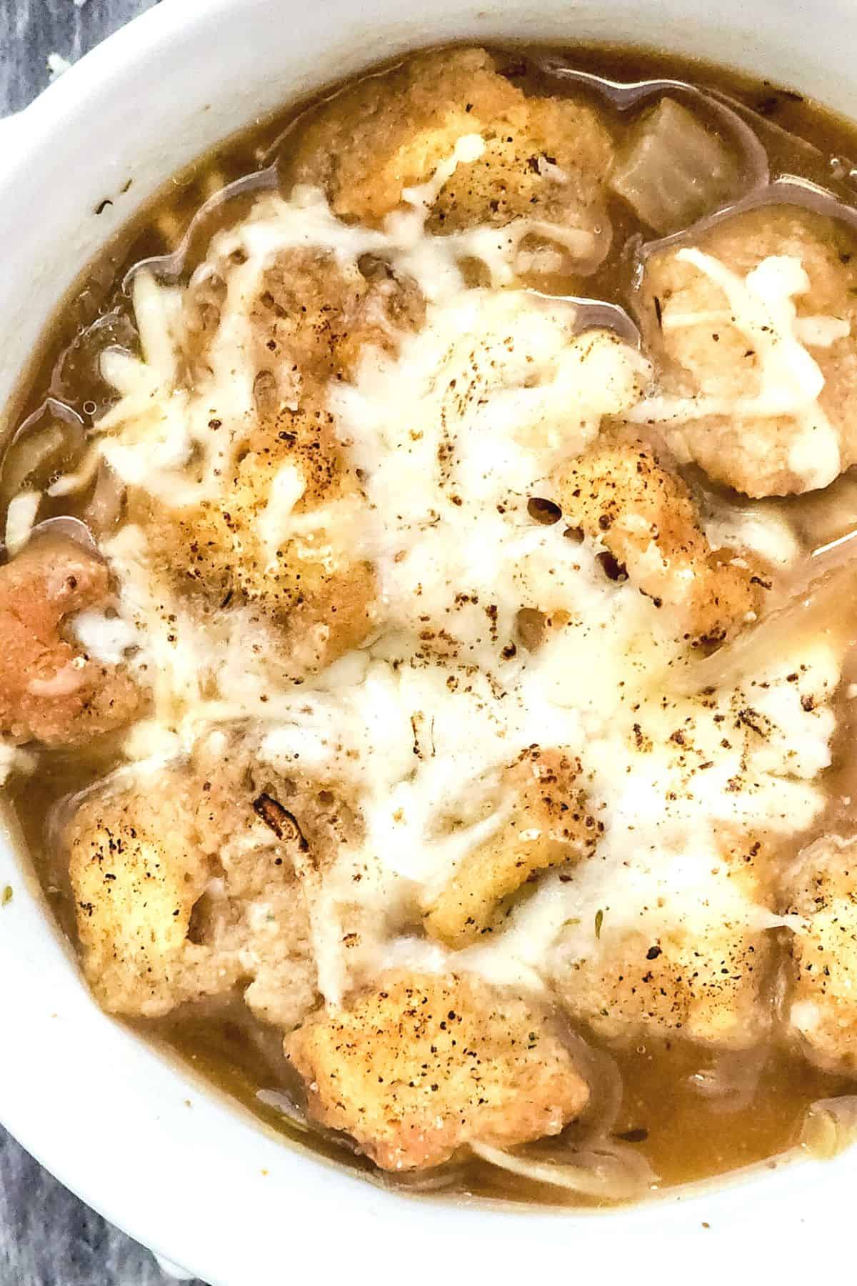 Top down view of crouton-topped French onion soup.