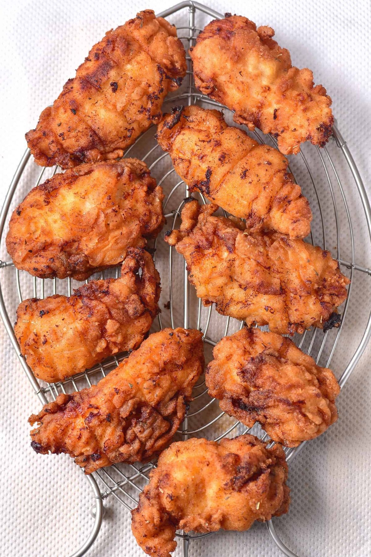 Dairy-free fried chicken cooling on wire rack.