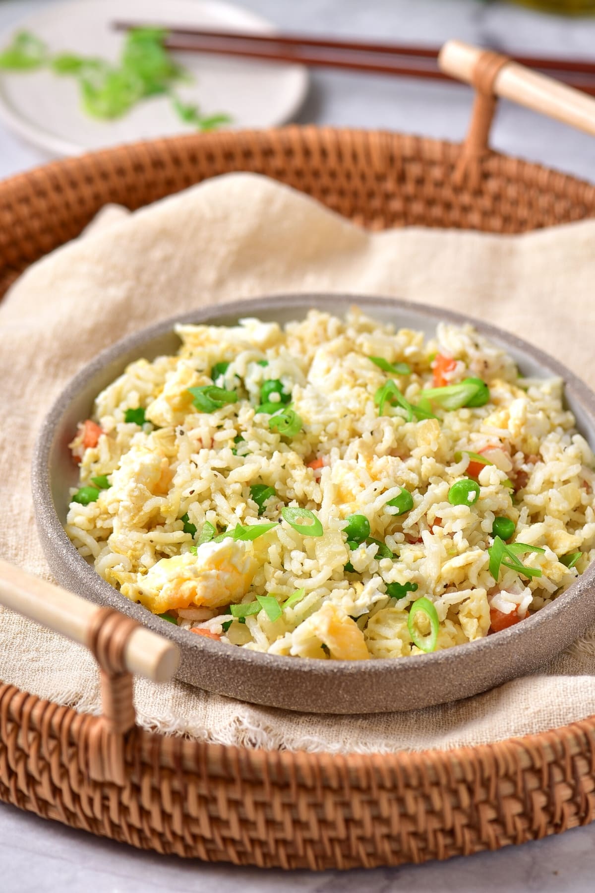 A bowl of fried rice in a brown wicket basket.