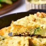 Holding up a portion of frittata from skillet.