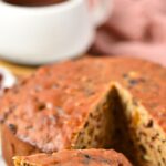 A slice of fruit cake on wooden board