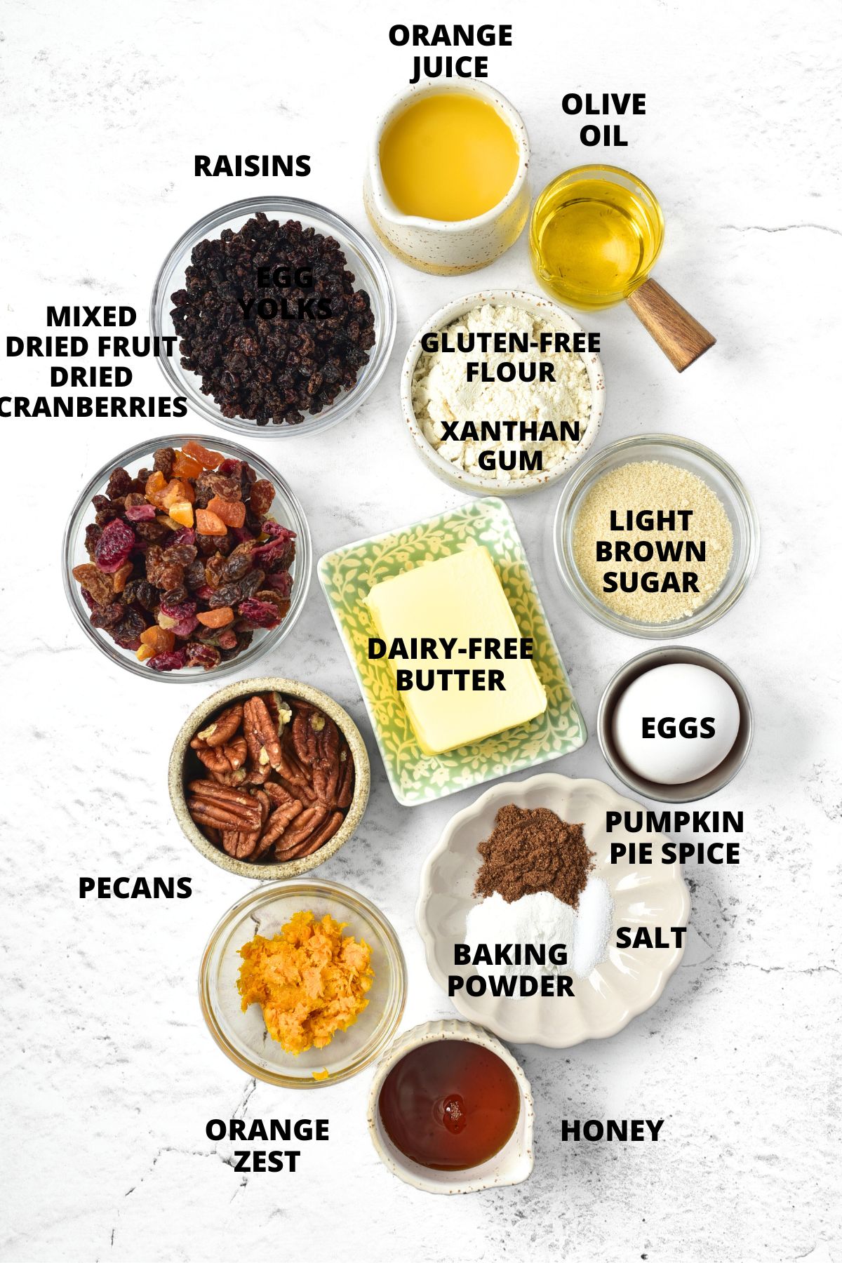 Ingredients for making gluten-free fruit cake recipe laid out on marble board.