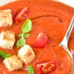 A spoon in a bowl of tomato gazpacho