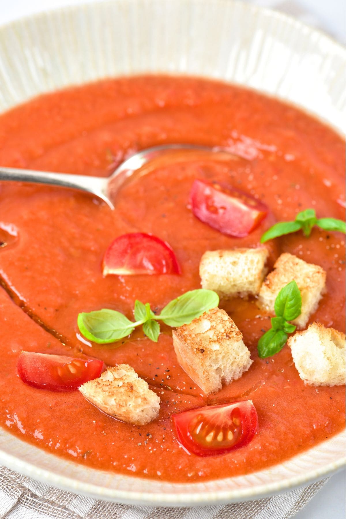 A bowl of gluten-free gazpacho soup topped with croutons
