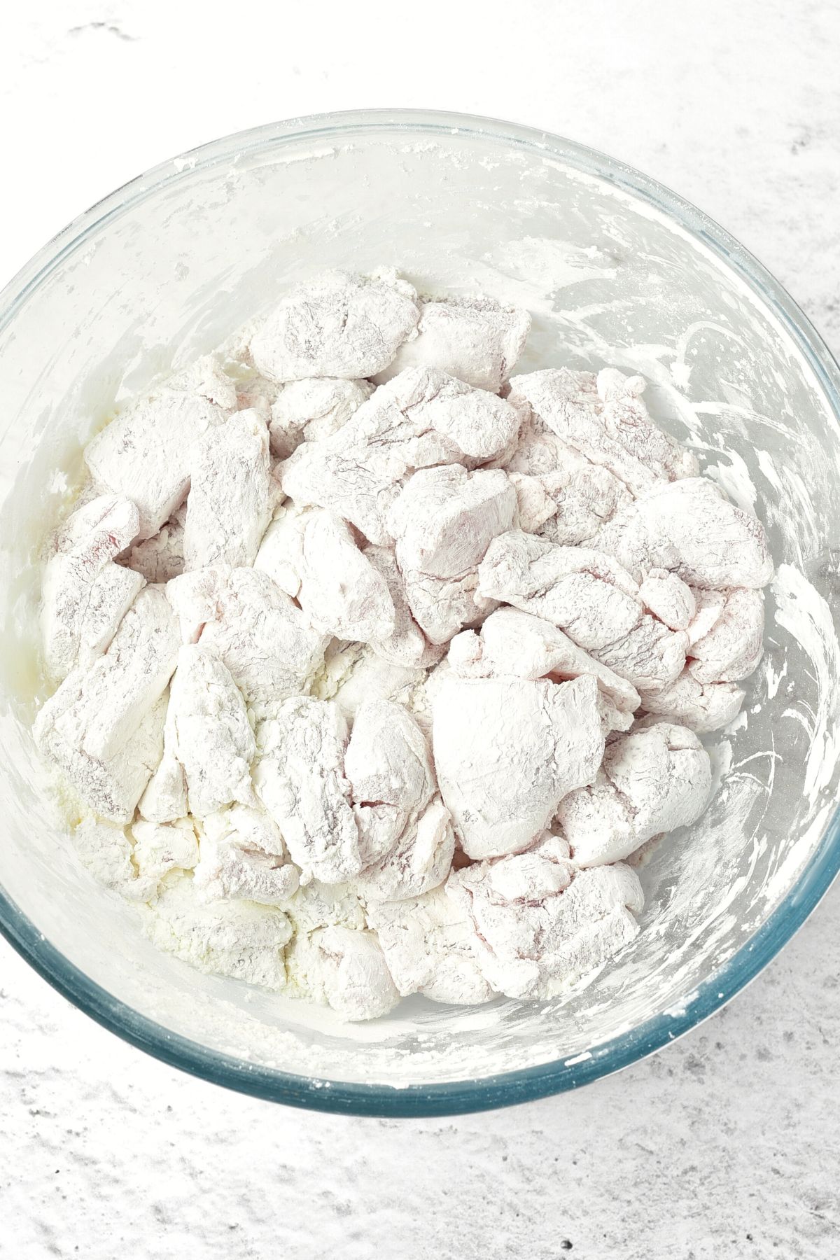 Tossing chicken pieces in cornstarch in bowl