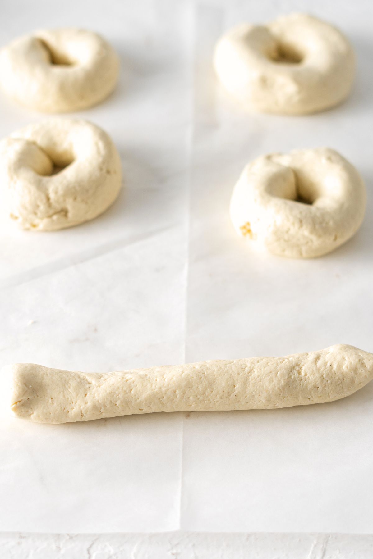 Shaping bagel dough on parchment paper
