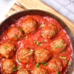 Top down view of a skillet with meatballs in marinara sauce.