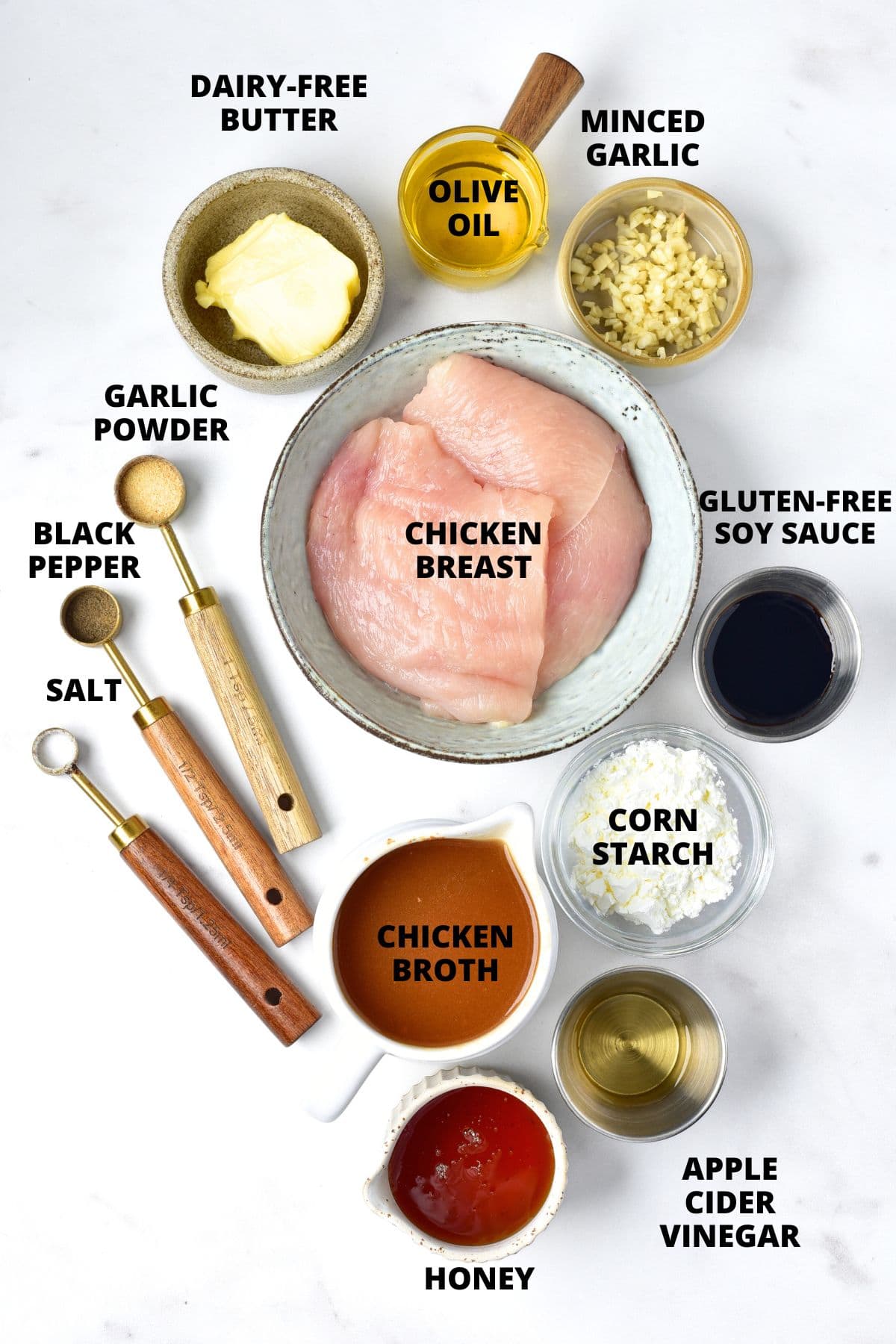 Ingredients for gluten-free honey garlic chicken recipe on marble board.