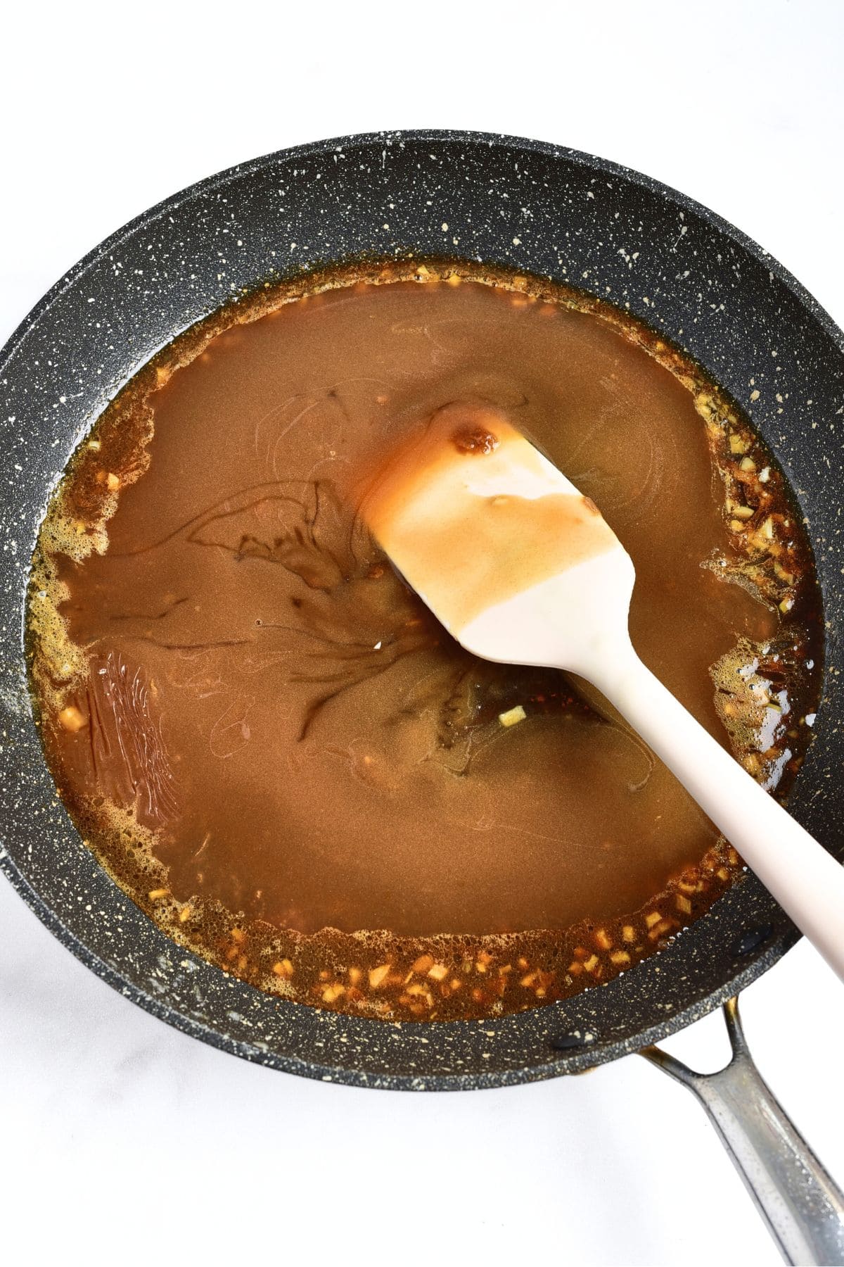 Cooking gluten-free honey garlic sauce in skillet