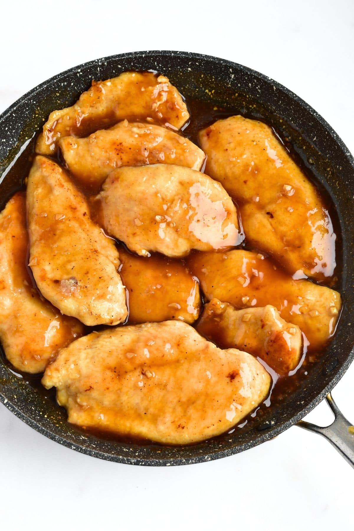 Chicken fillets in brown sauce in skillet