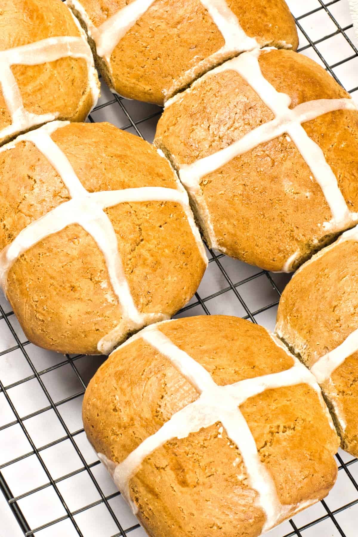 Up close shot of easter hot cross buns on a cooling rack.