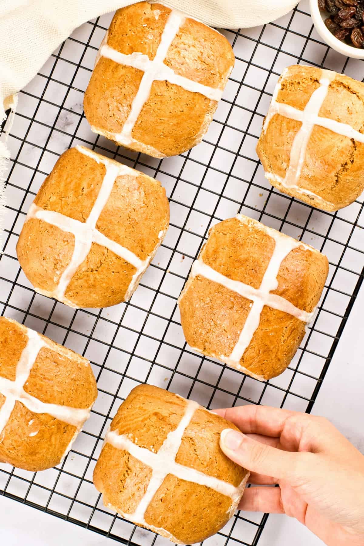 Hot cross buns on a cooling rack.