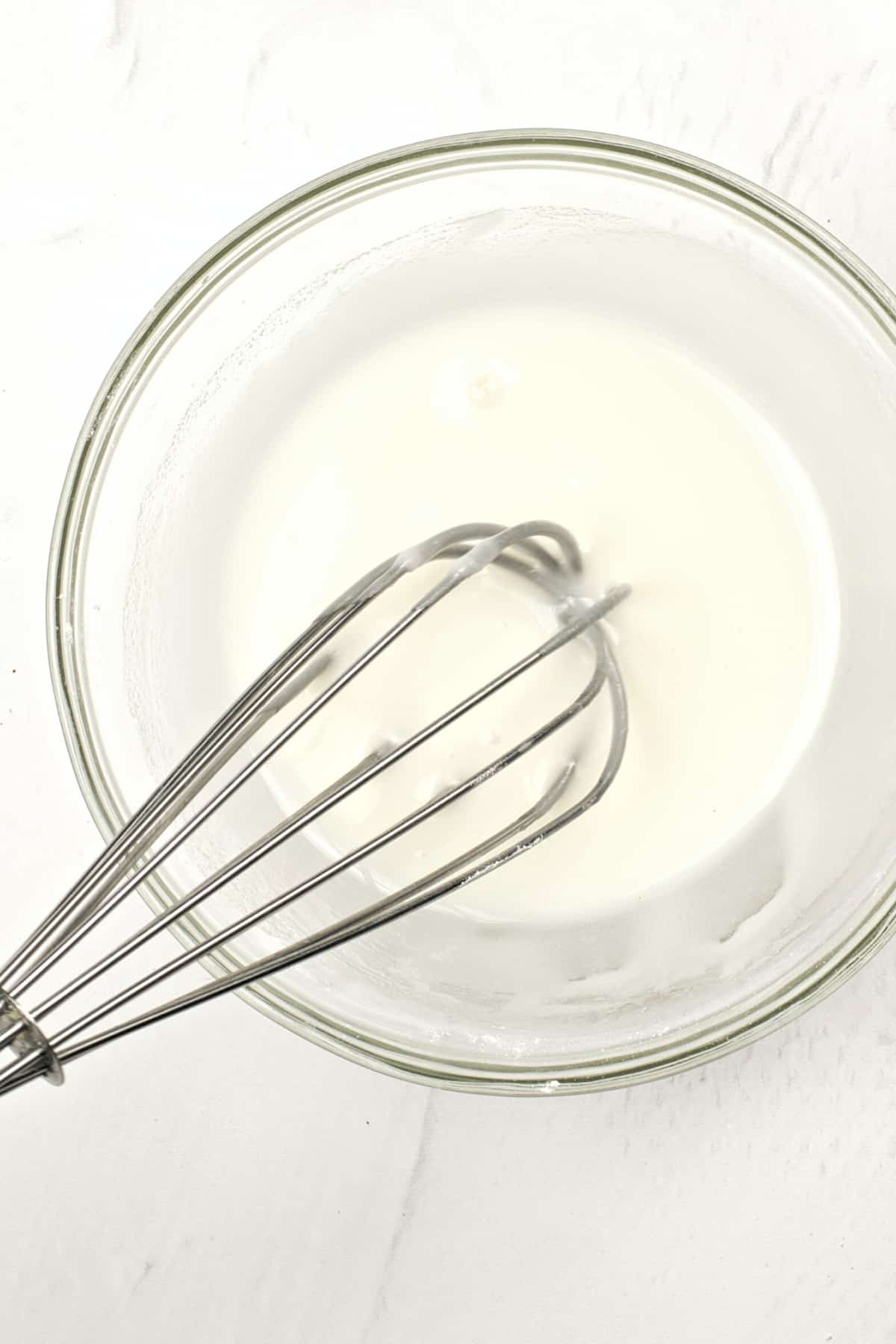 Whisking icing in glass bowl.