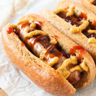 Hot dogs topped with mustard and ketchup.
