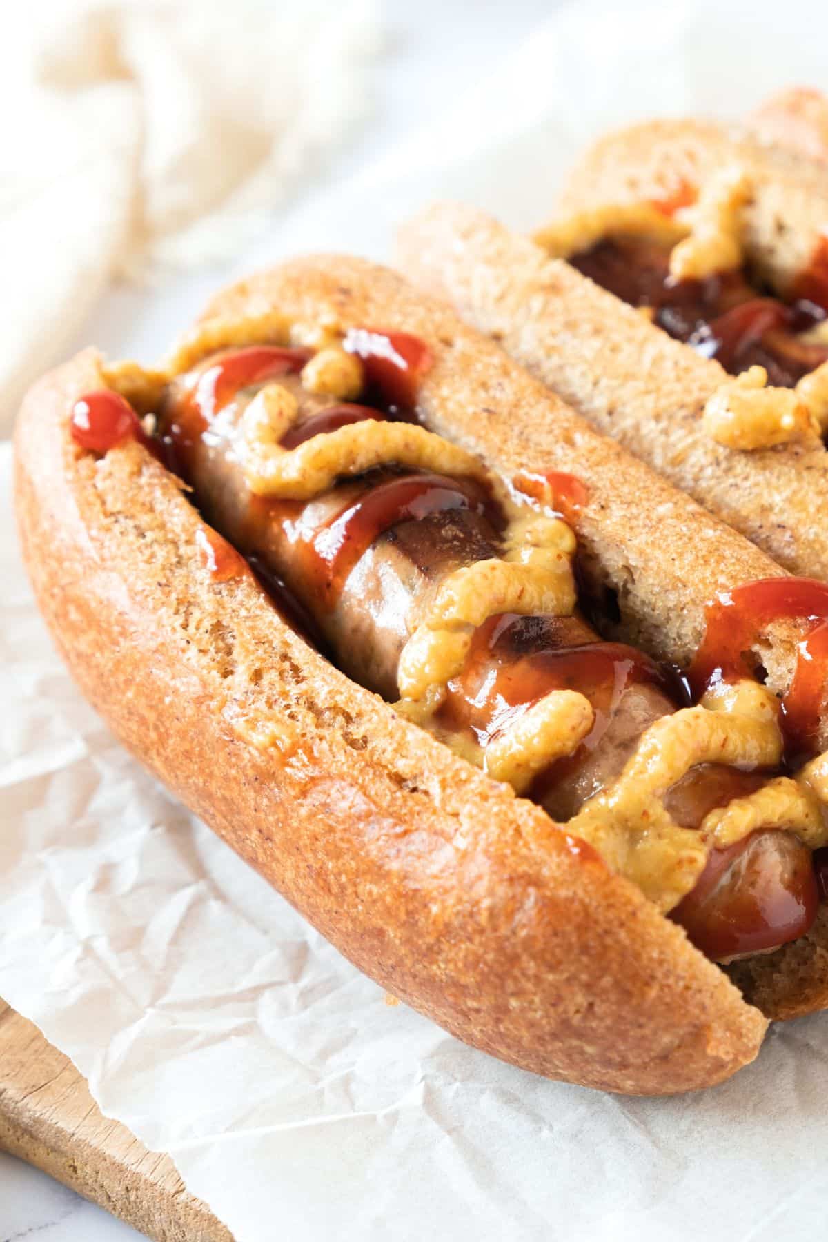 Up close shot of gf hot dogs topped with mustard and ketchup.