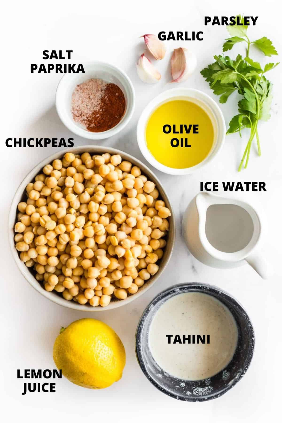 Ingredients required for gluten free hummus recipe laid out on marble board.