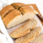 Sliced loaf of Irish brown soda bread on wooden board.