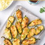 Top down view of jalapeño poppers on parchment-lined board.