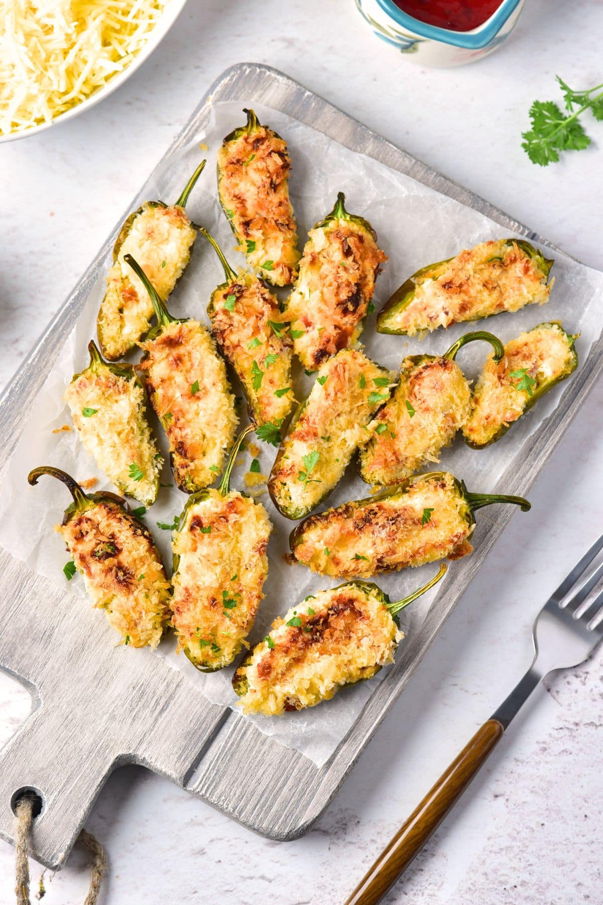 Top down view of jalapeno poppers on wooden board.