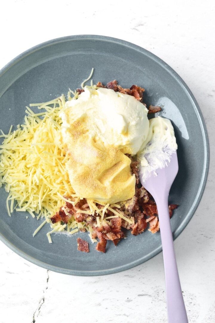 Cheese, cream cheese and bacon bits in a bowl