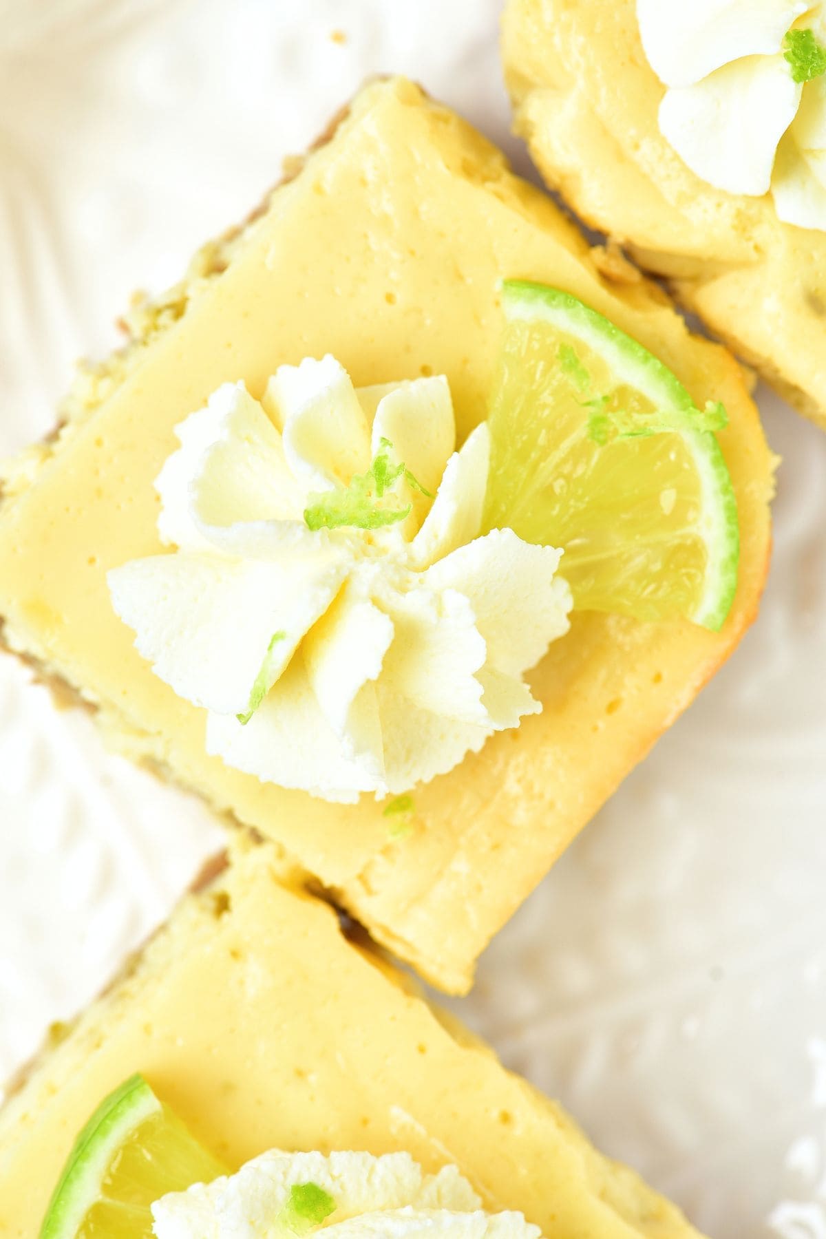 Top down view of key lime bars topped with whipped cream