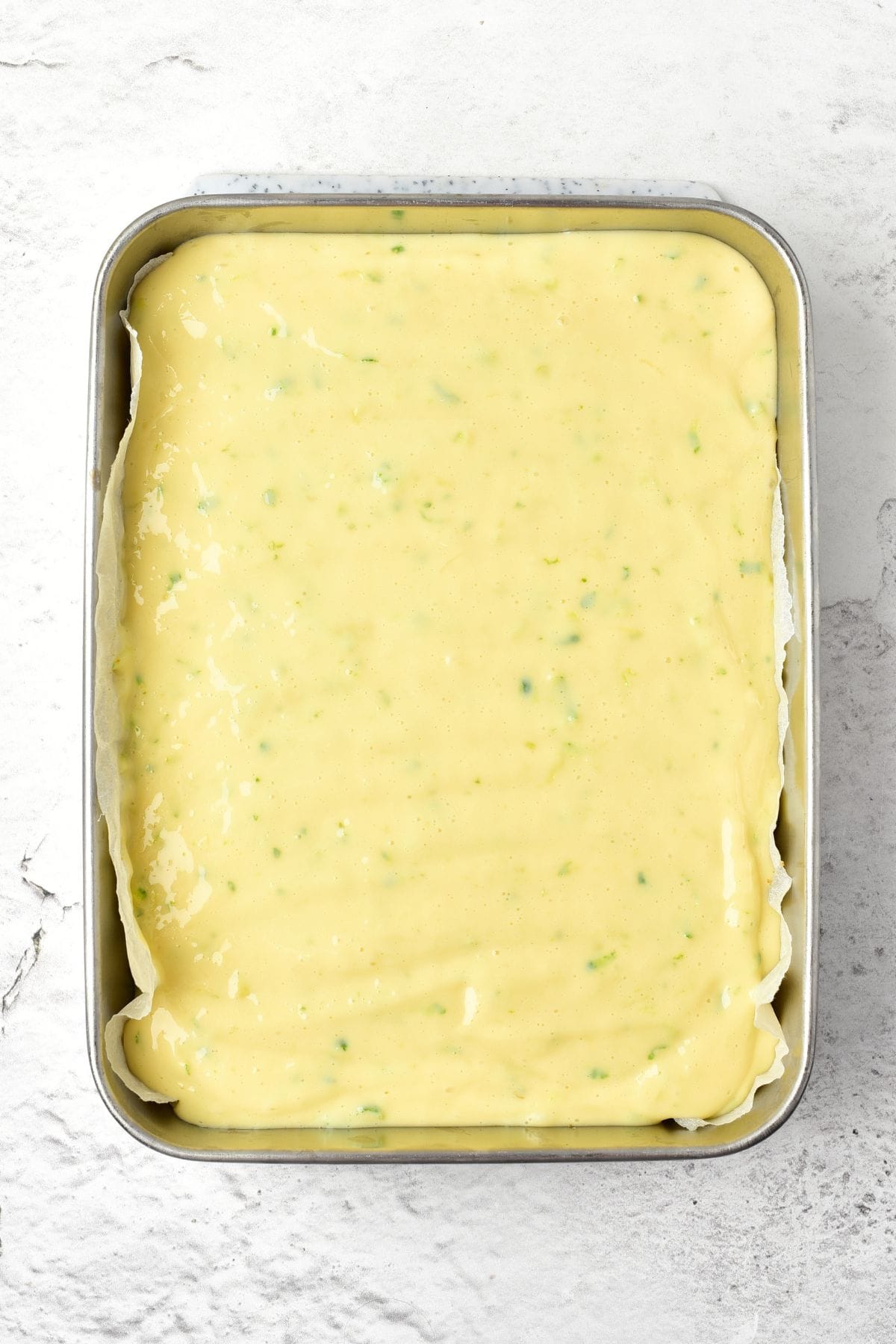 Key lime filling in a parchment-lined metal baking pan